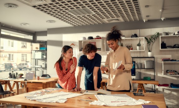 Trois personnes regardent une feuille de papier