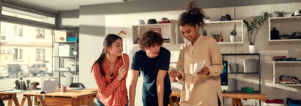 Trois personnes regardent une feuille de papier