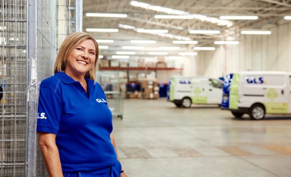  A GLS woman stands smiling in a GLS depot
