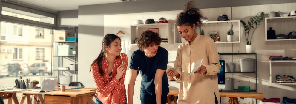 3 angajați tineri lucrând împreună la un proiect 